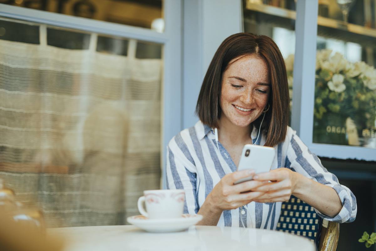 woman smiling and looking at her phone